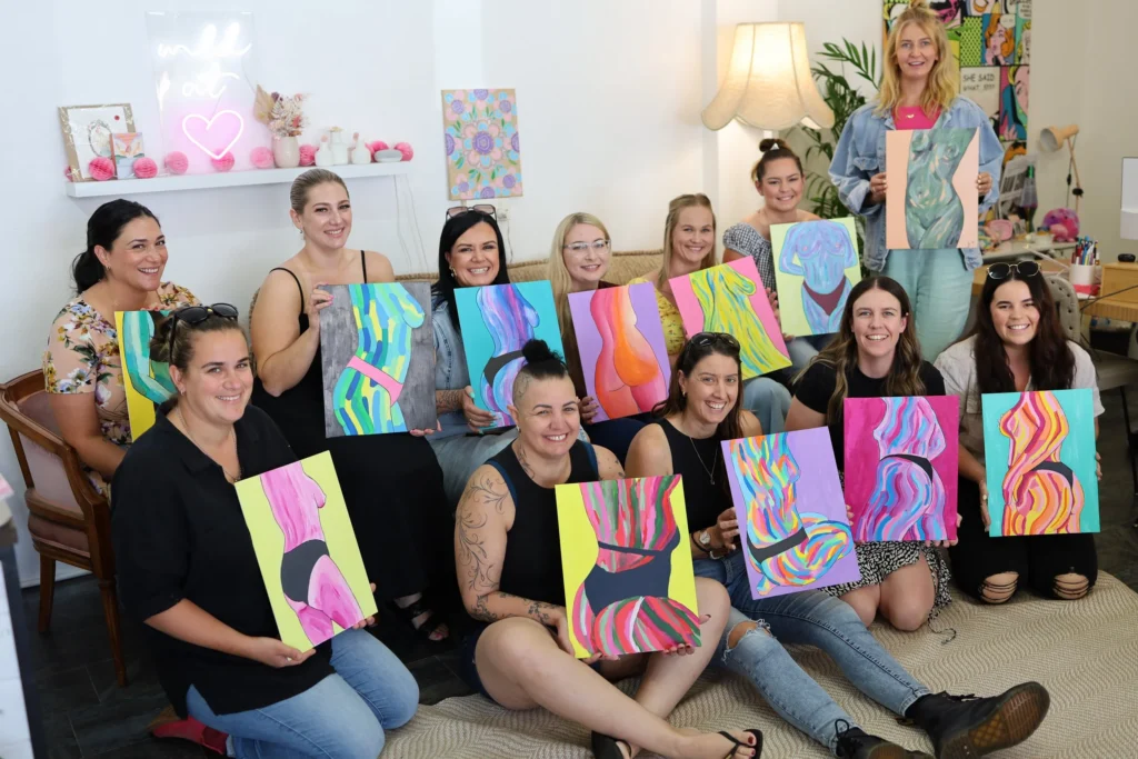 Women holding their painting proudly